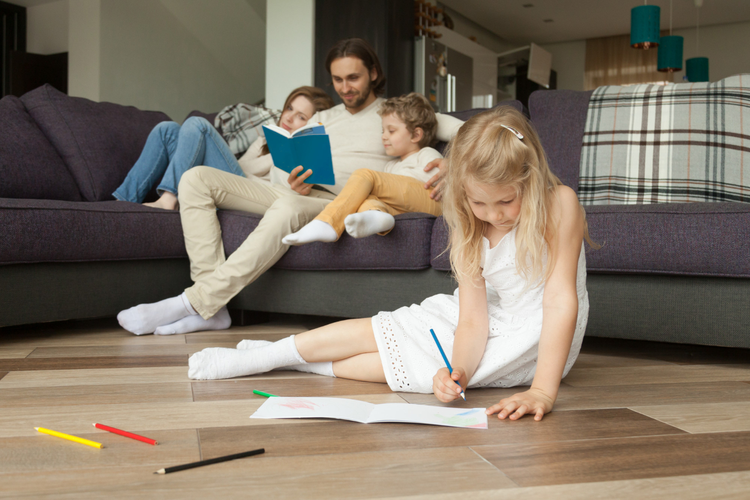 daughter-playing-floor-while-parents-son-reading-book (1)